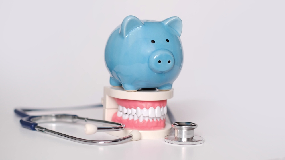 blue piggy bank on top of a set of fake plastic teeth