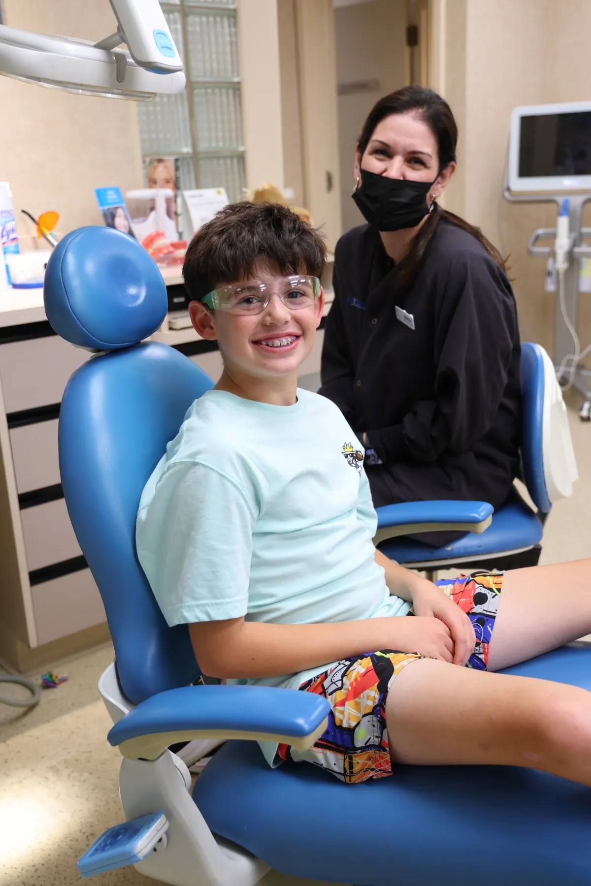 Smiling young patient seated in a dental chair at Hamilton Dental Associates